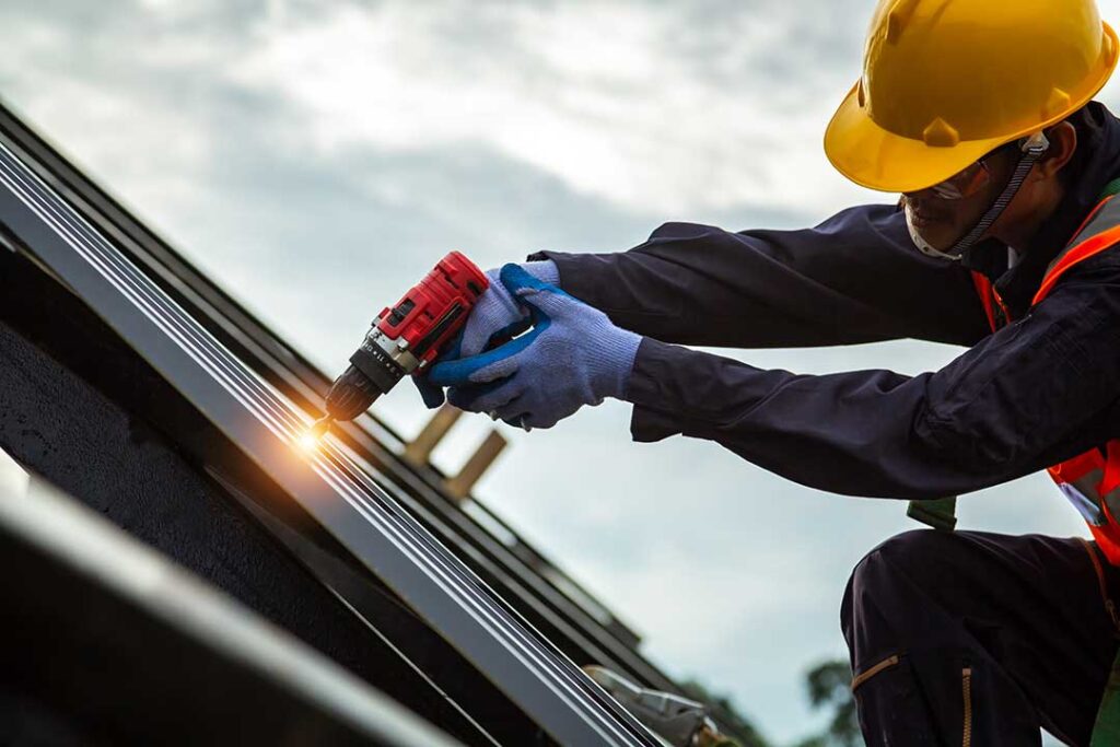 Person in slip-resistant shoes carefully walking on a dry shingle roof beside a secured ladder.