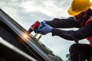 Person in slip-resistant shoes carefully walking on a dry shingle roof beside a secured ladder.