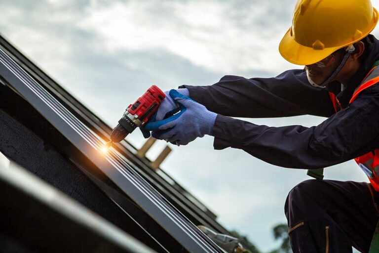 Person in slip-resistant shoes carefully walking on a dry shingle roof beside a secured ladder.
